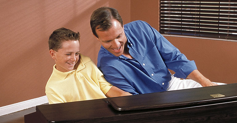 Father and son playing a Clavinova