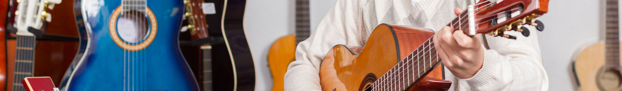 Man playing acoustic guitar in music shop