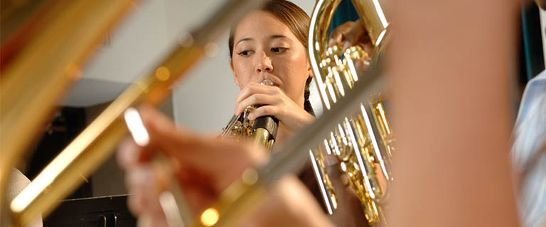 Girl playing the french horn in class