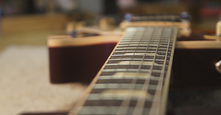 Closeup of a guitar from the top down the neck